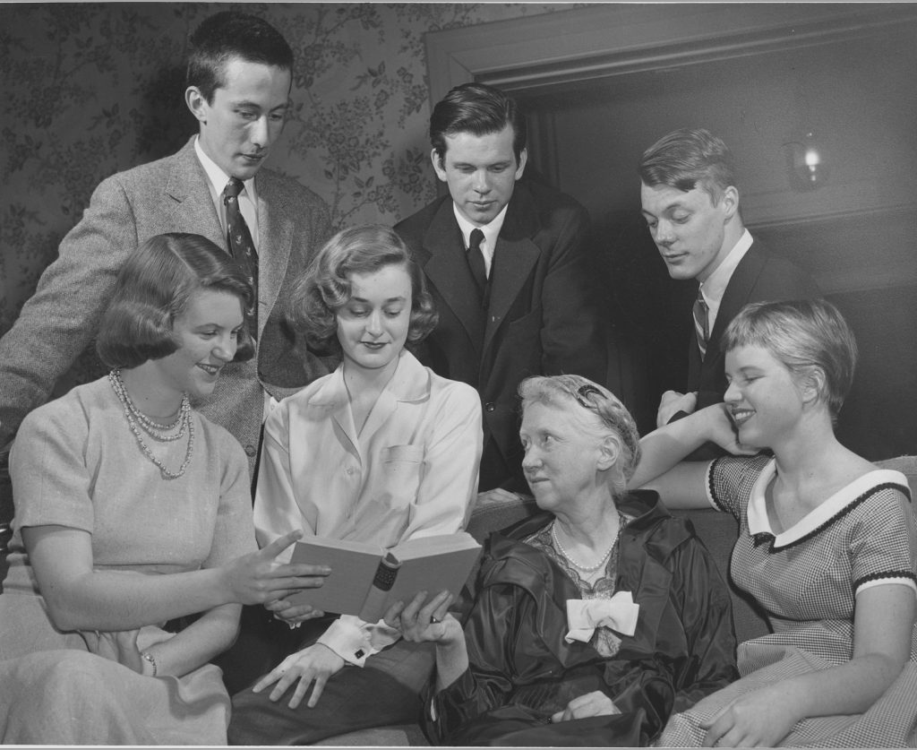 Marianne Moore meeting with contestants for the 1955 Glascock Poetry Contest - in the front row are Sylvia Plath (Smith), Lynne Lawner (Wellesley) Marianne Moore, Jean Piser (Mount Holyoke); in the back row are David Rattray (Dartmouth), William Key Whitman (Wesleyan), and Donal Lehmkuhl (Columbia).
