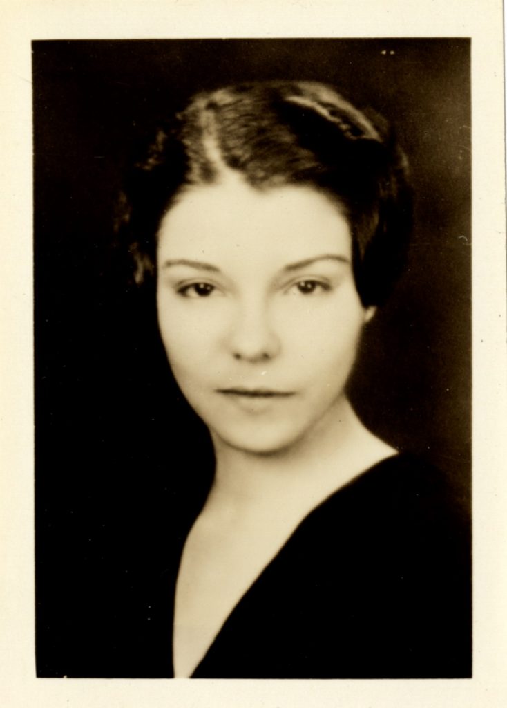Olga de Quintero, shown in a waist-up shot, wears a black top with her hair tied up. Llamarada 1933.