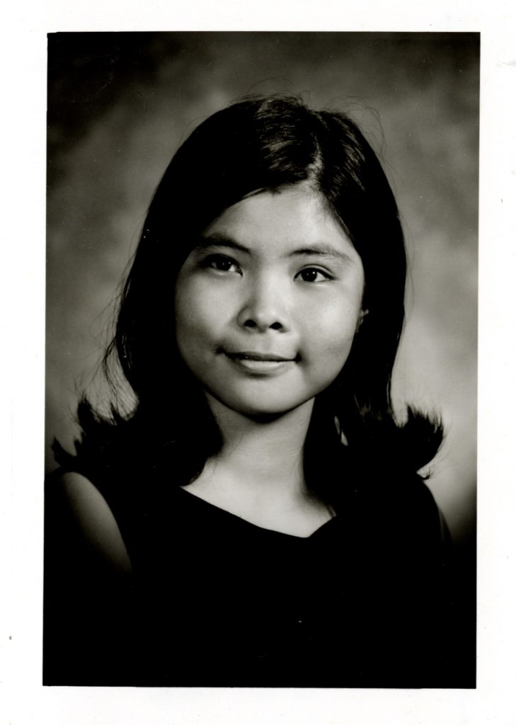 Josette Ngan-Hoa Huynh smiles in a waist-up shot, her hair in shoulder-length style.