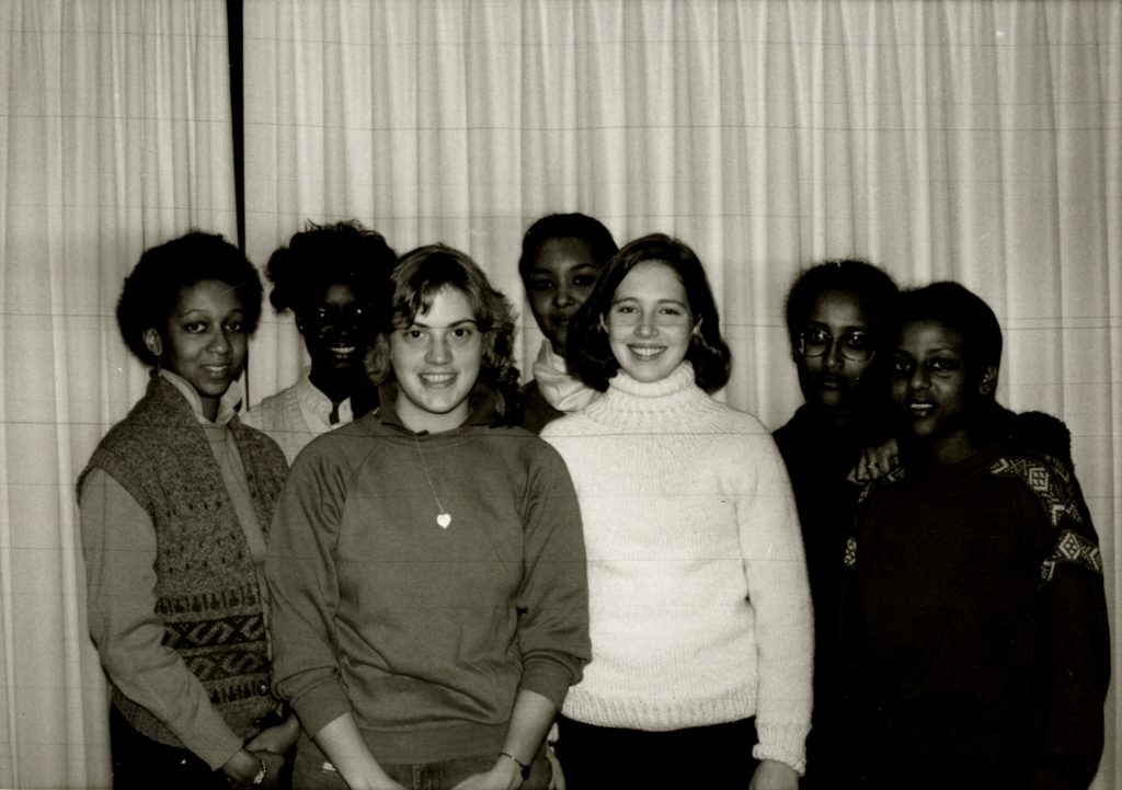 Six smiling students in sweaters gathered together for a club photograph.