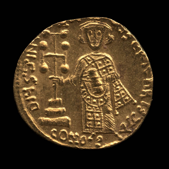 A gold coin set against a black background. The coin is slightly misshapen and depicts Byzantine Emperor Justinian II surrounded by text.
