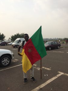 Un jeune homme à l'aéroport avec le drapeau du Cameroun / A young man at the airport with the Cameroonian flag