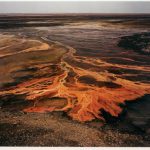 1. What elements of this photograph stand out for you? 2. Do you think this photograph is beautiful? 3. What attitude do you think the photographer has towards nature? 4. How does finding out that the intense colors in this photograph are due to toxic chemicals that have been dumped onto the land?